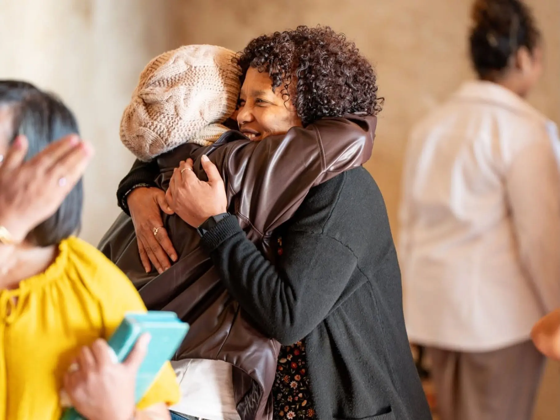 Two women from a church community embracing in the lobby